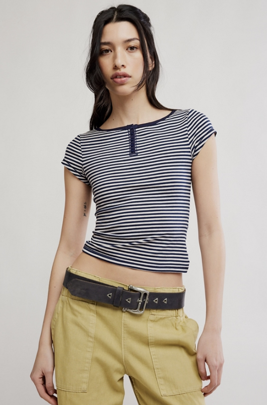 Woman wearing navy stripe shirt and green pants on white background