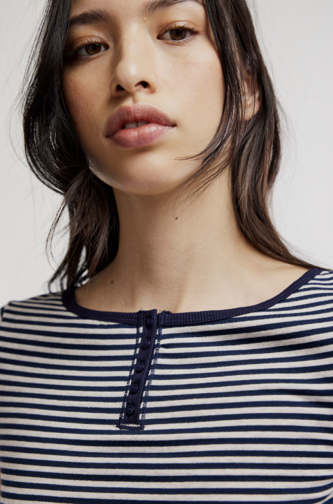 Woman wearing a striped shirt with a plain background