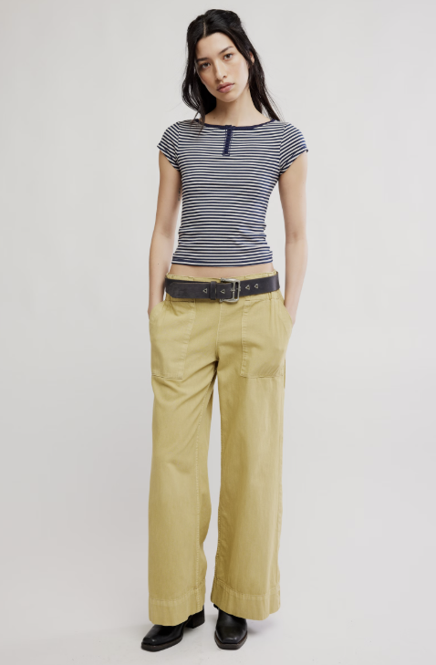 Woman wearing a striped shirt and beige pants on a white background