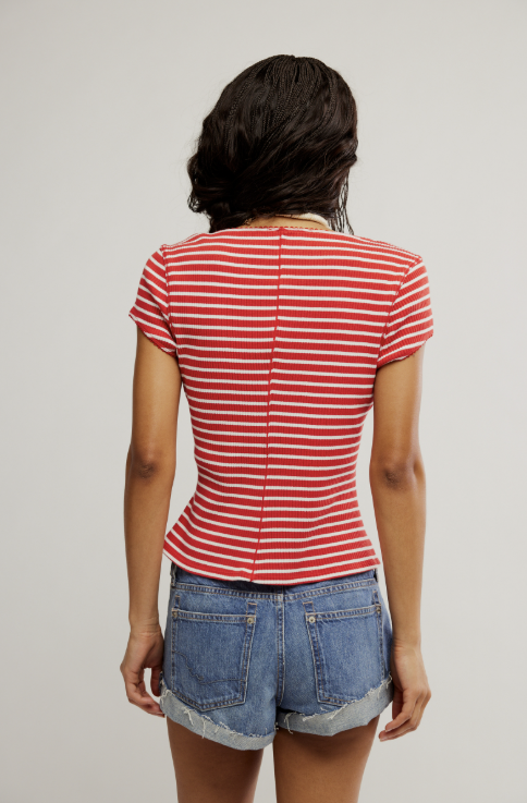back of woman wearing red and white stripe shirt and blue jean shorts on white background