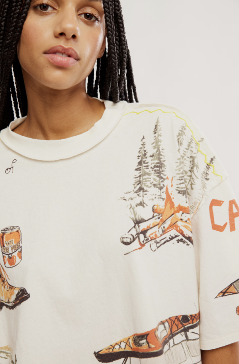 Person wearing a white sweatshirt with nature-themed graphics on a plain background