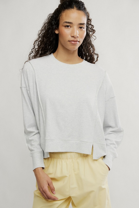 Woman wearing grey shirt and yellow pants on white background