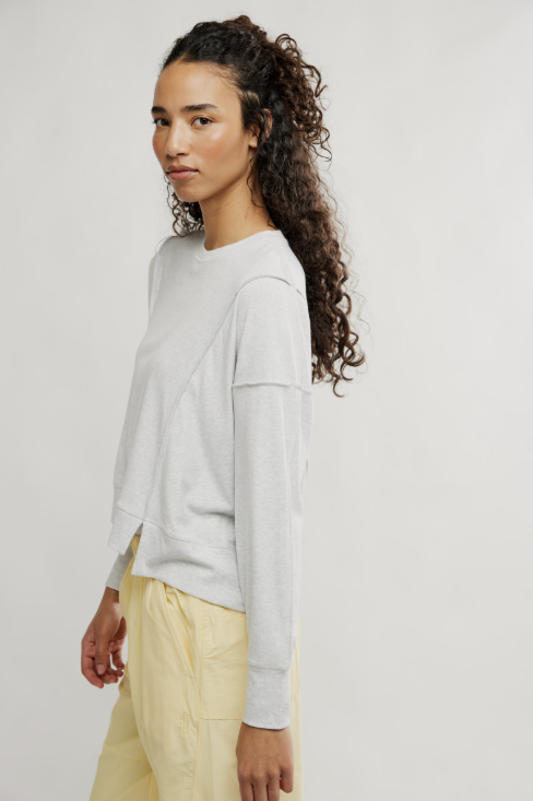 Woman wearing grey shirt and yellow pants on white background