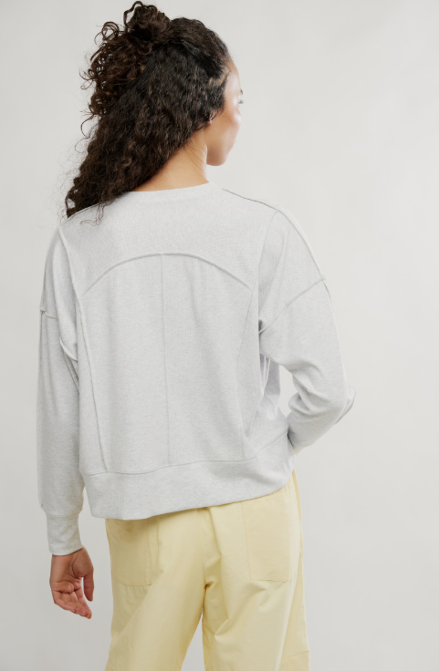 Woman wearing grey shirt and yellow pants on white background