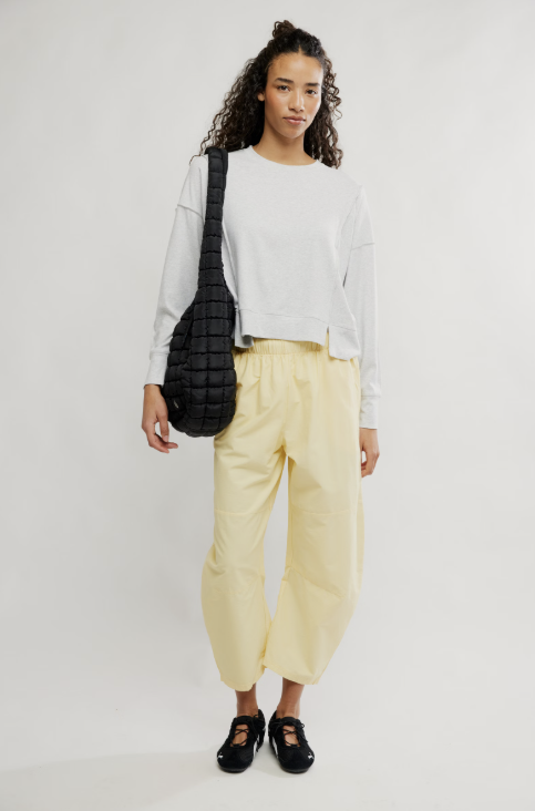 Woman wearing grey shirt and yellow pants on white background