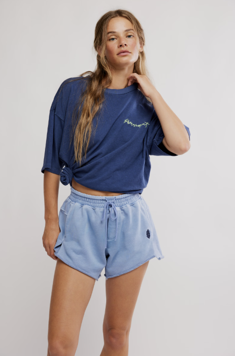 Woman wearing blue tee and shorts on white background
