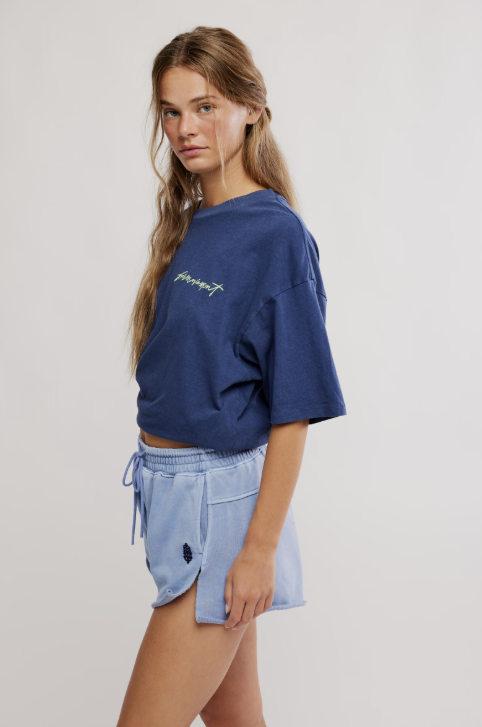 Woman wearing blue tee and shorts on white background
