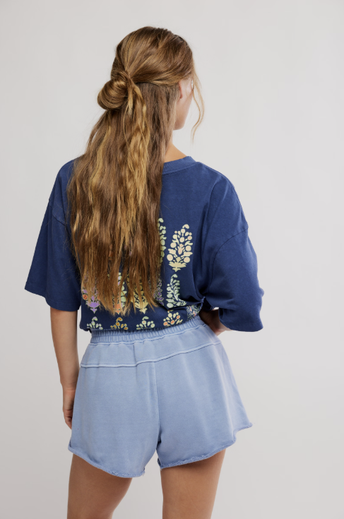 Woman wearing blue tee and shorts on white background