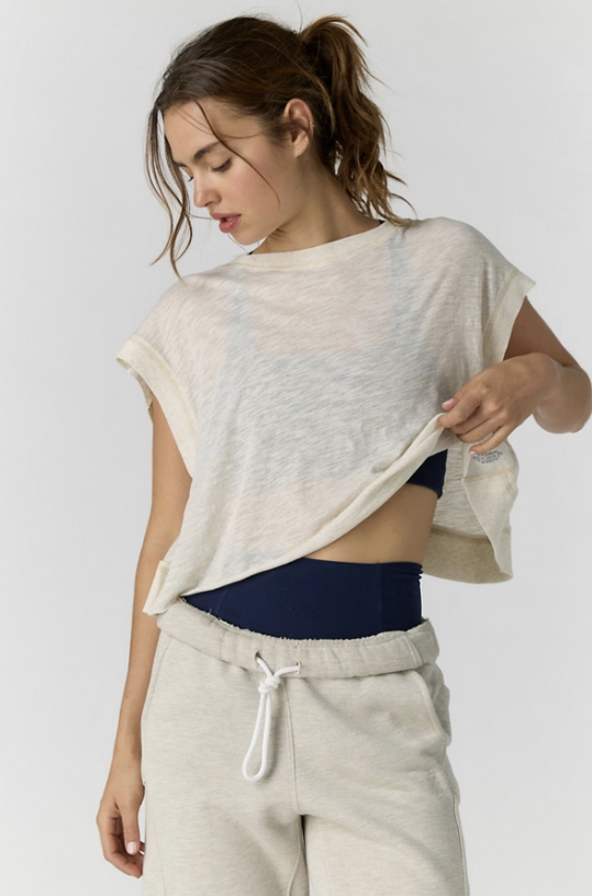 woman wearing beige tee and sweatpants on white background