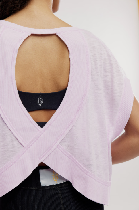 Light purple top with open back worn by a person on a white background