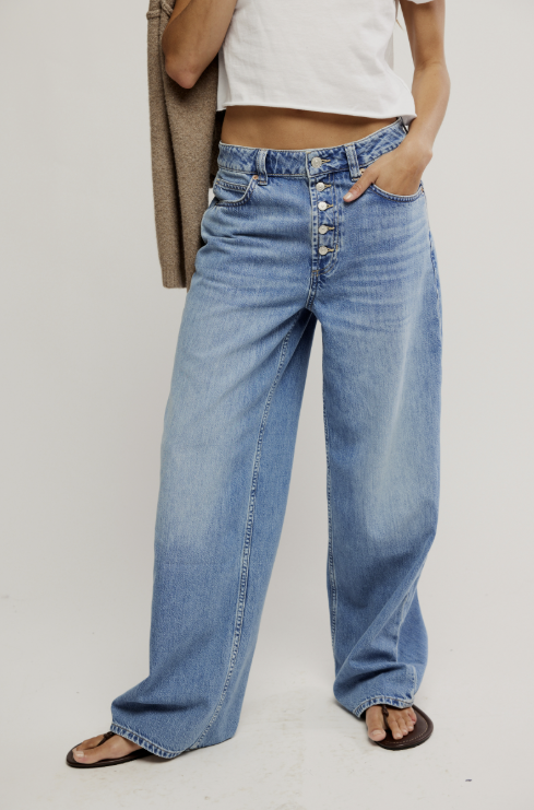 Person wearing blue jeans on a plain background