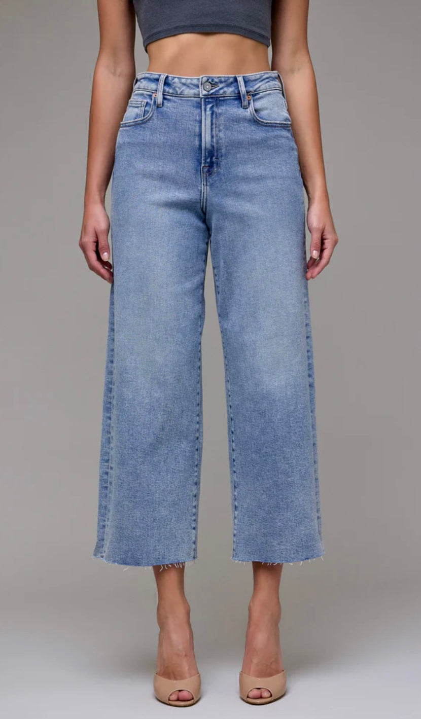 Person wearing light blue jeans on a plain background