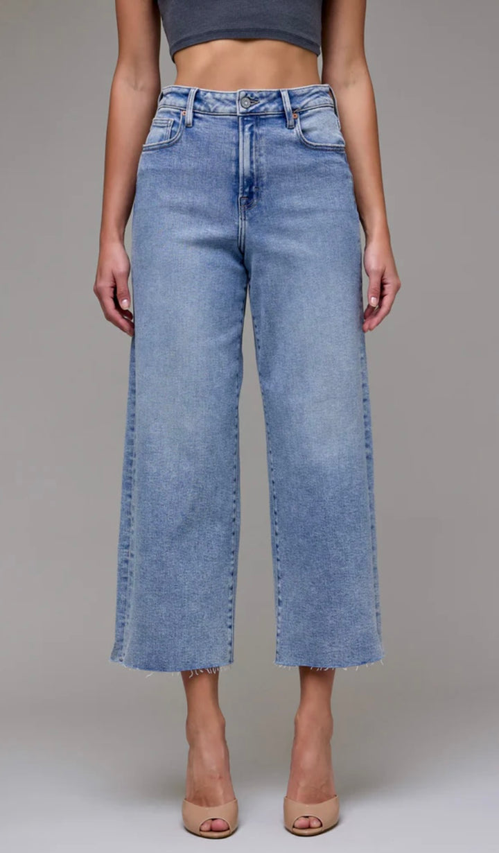 Person wearing light blue jeans on a plain background