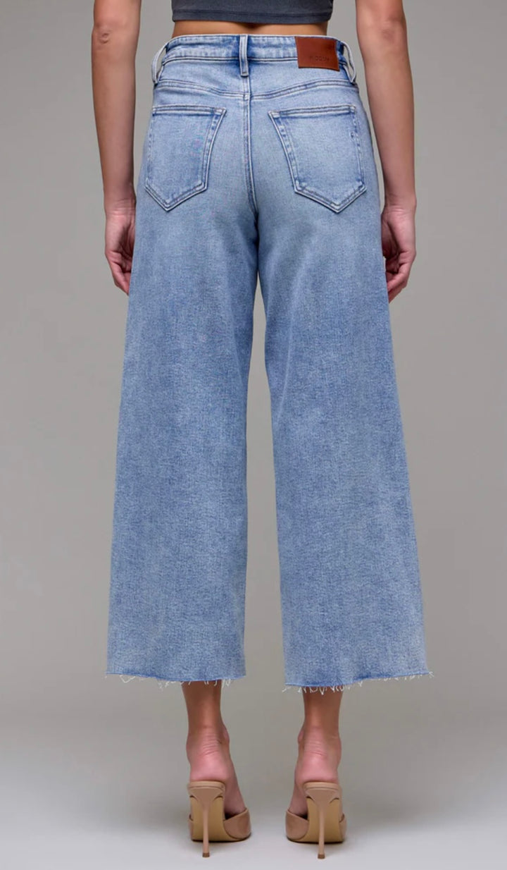Light blue jeans worn by a person on a gray background