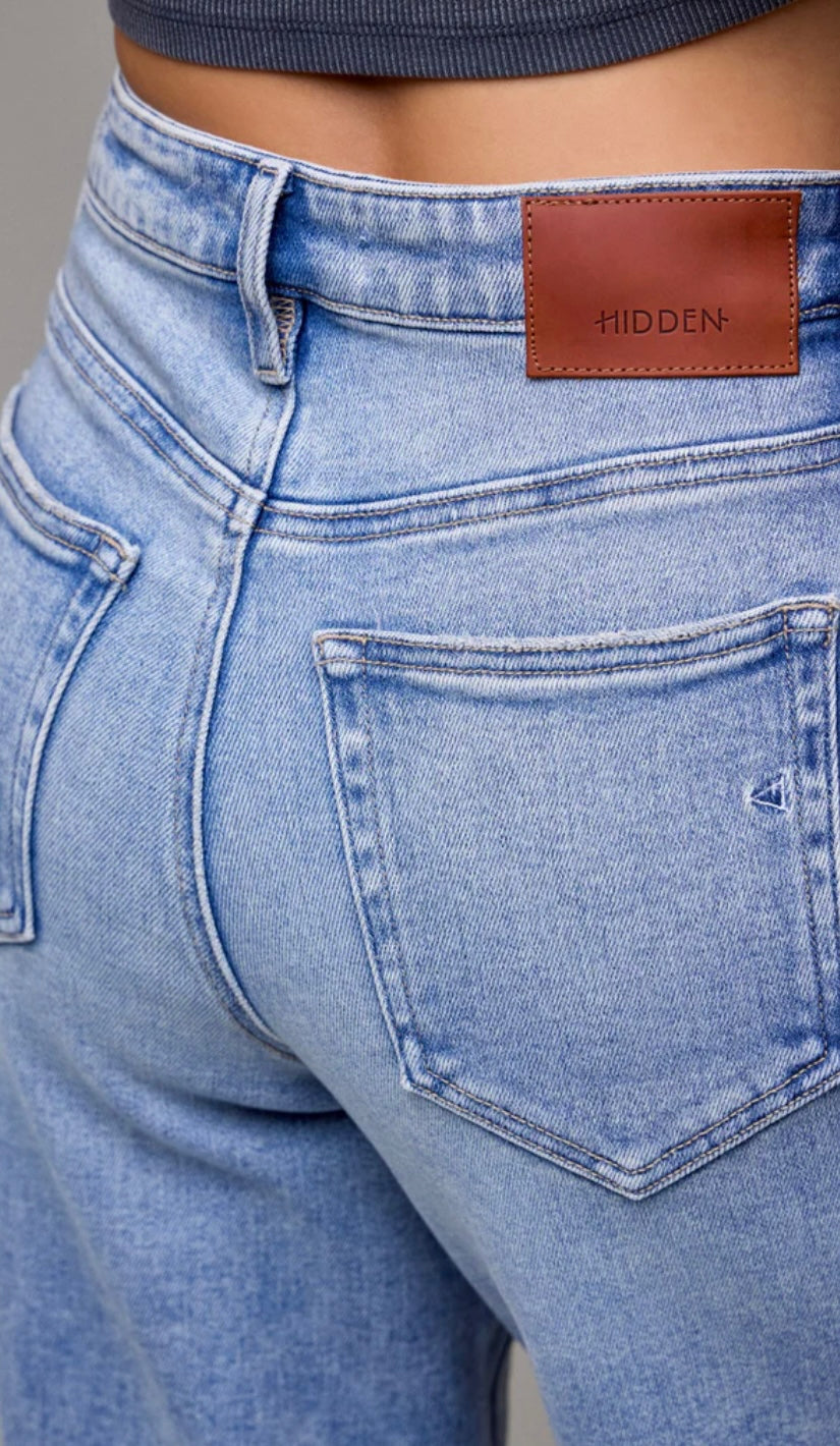 Close-up of blue jeans with a brown leather patch displaying &