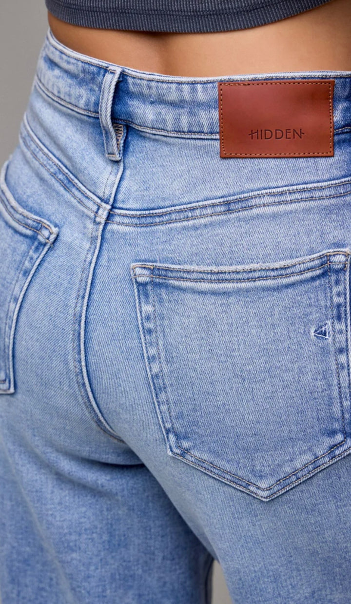 Close-up of blue jeans with a brown leather patch displaying &