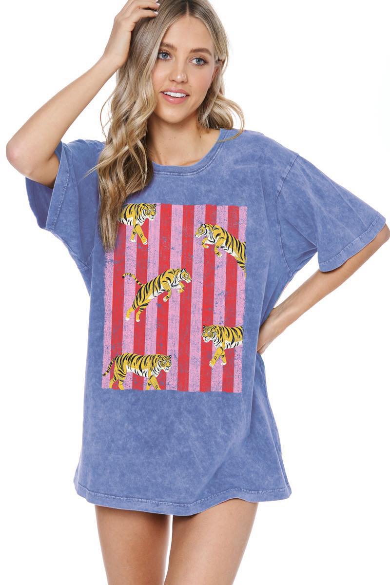 Woman wearing blue graphic tee with tigers on plain background