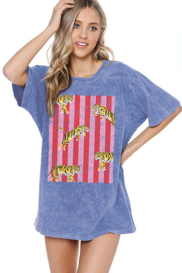 Woman wearing blue graphic tee with tigers on plain background