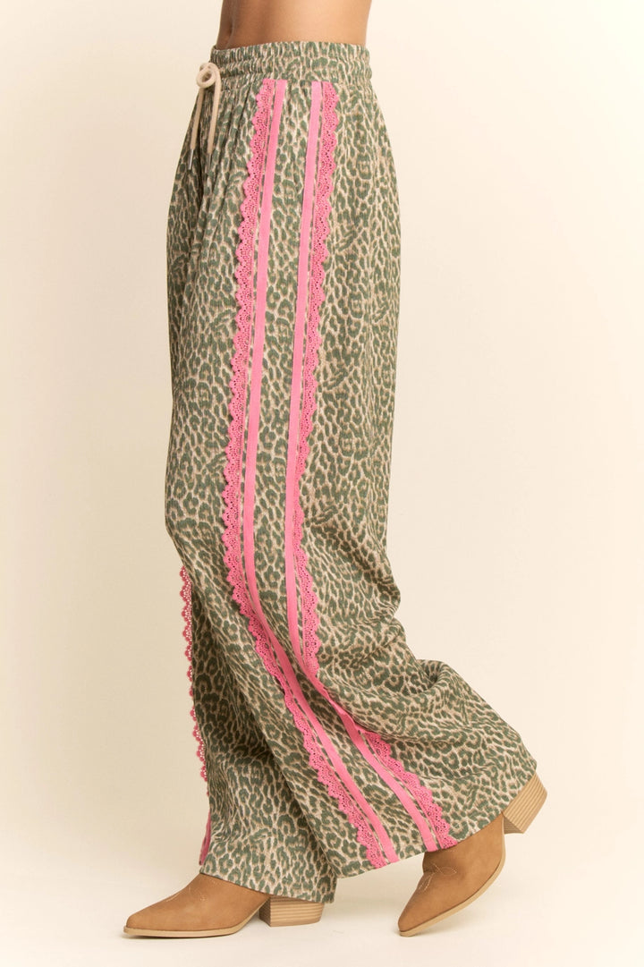 Leopard print pants with pink trim on a beige background