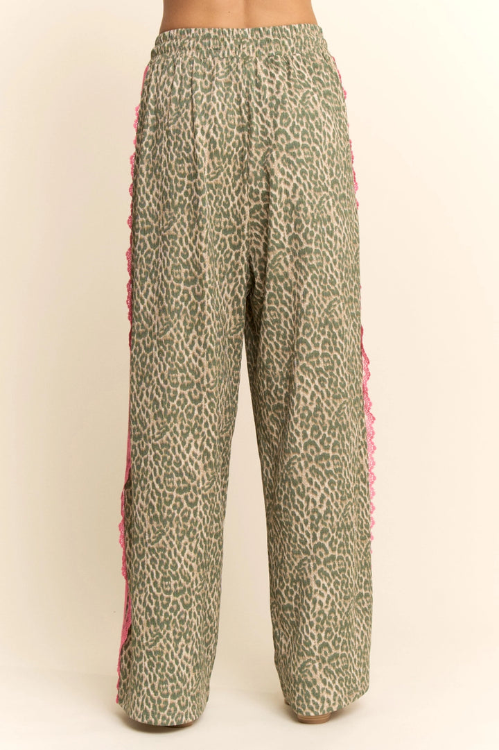 Leopard print pants with pink trim on a beige background