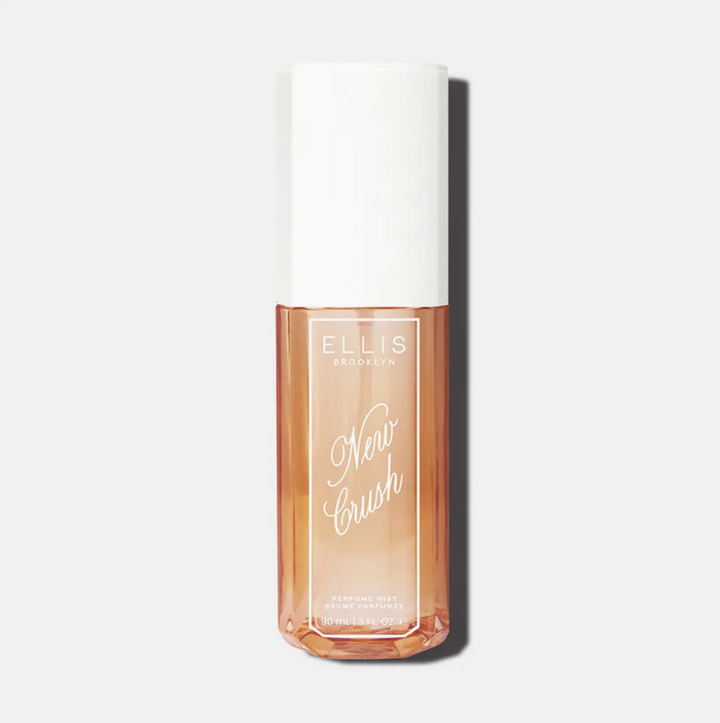 Ellis Brooks New Brush Primer in a clear rectangular bottle showing the peach-toned liquid inside, topped with a white cap, on a light gray background.