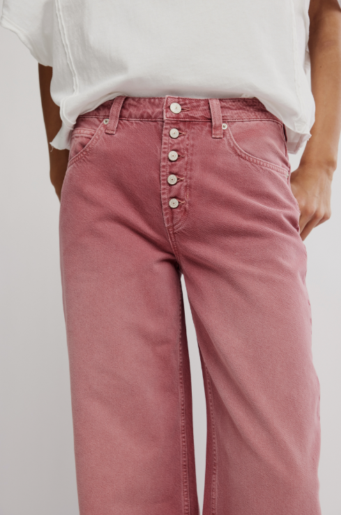 Person wearing pink jeans with a white background
