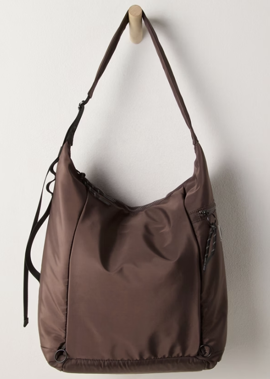Brown tote bag hanging on hook on plain wall