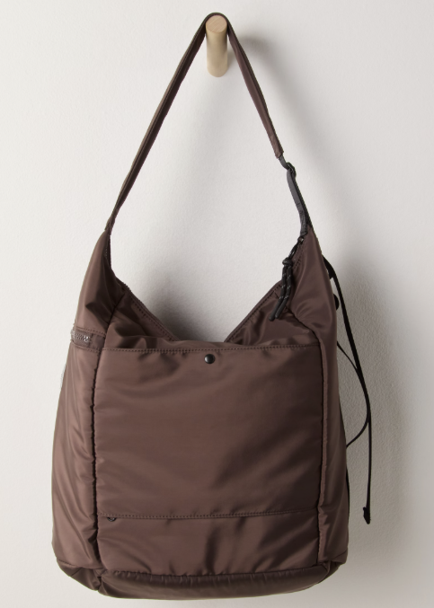 Brown tote bag hanging from hook on plain wall