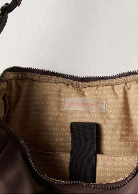 Inside of brown tote bag with writing and logo on plain background