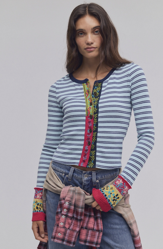 Woman wearing blue stripe cardigan with colorful detail on trim on white background
