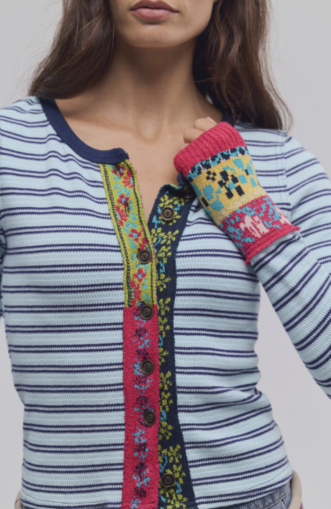 Close up of woman wearing blue stripe cardigan with colorful trim detail.