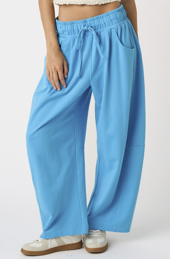 Woman wearing blue sweatpants on white background