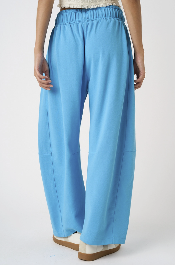 Woman wearing blue sweatpants on white background