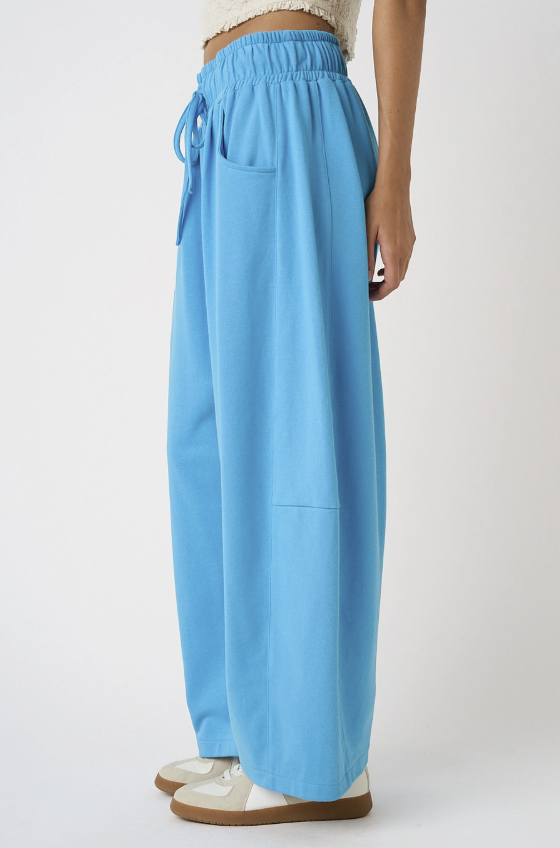 Woman wearing blue sweatpants on white background