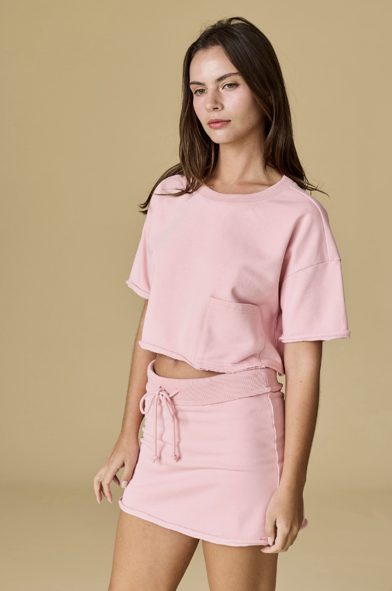 Woman wearing a pink outfit against a beige background