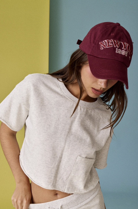 Woman wearing a maroon cap with &