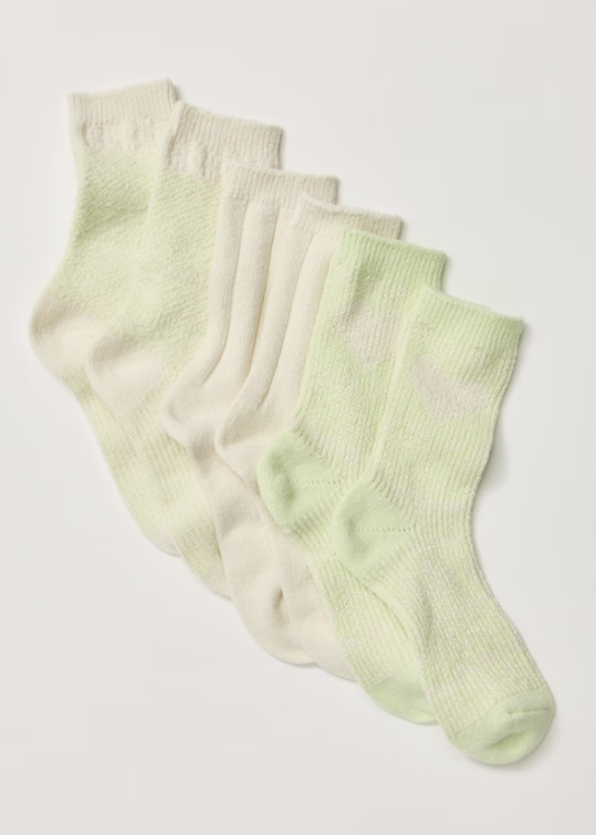 Set of lime green and beige socks on plain white background
