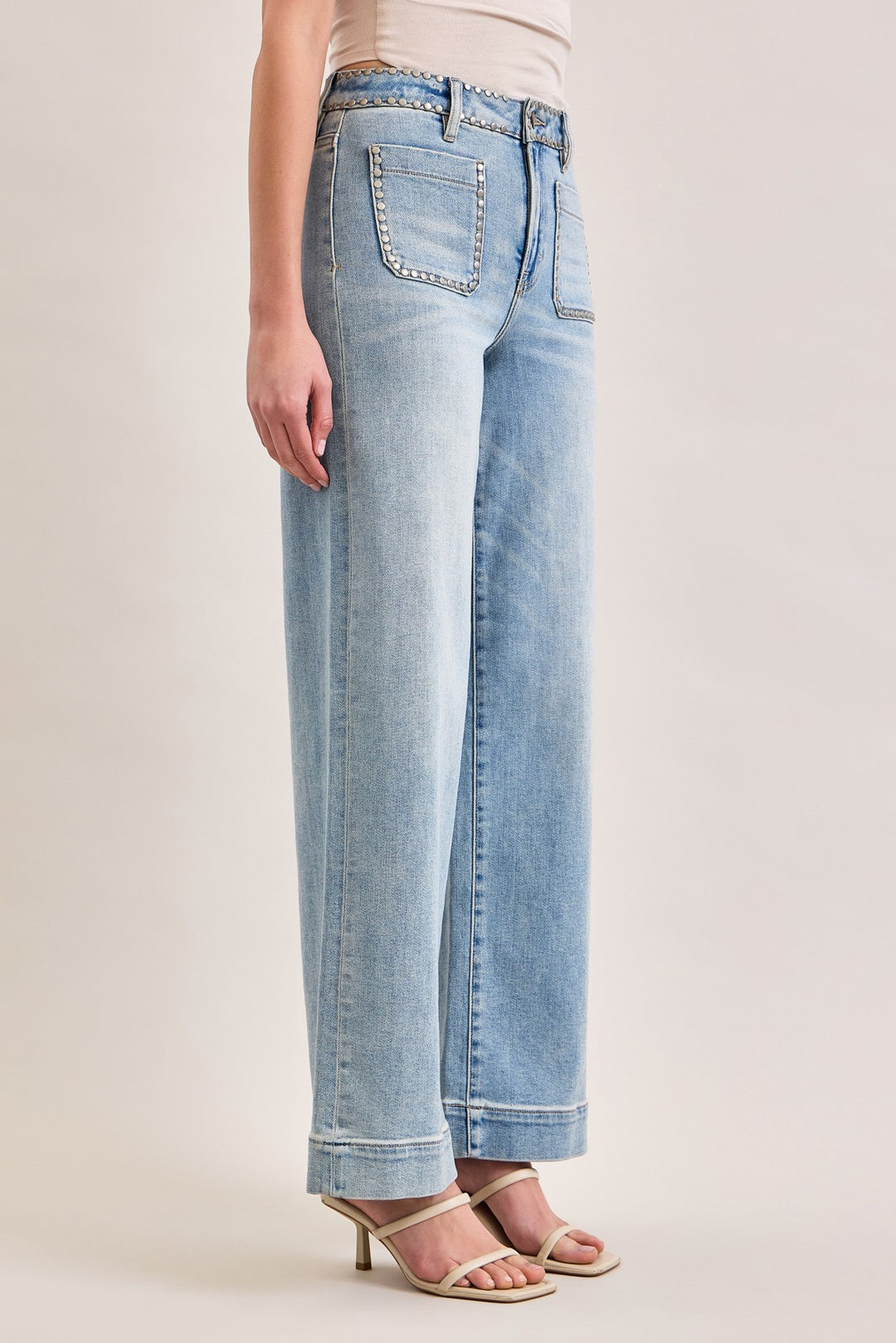 Light blue jeans worn by a person on a plain background