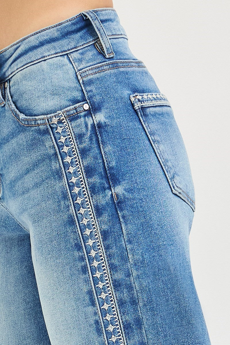 Close-up of blue jeans with star pattern on a white background