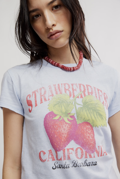 Woman wearing blue shirt with strawberries on white background