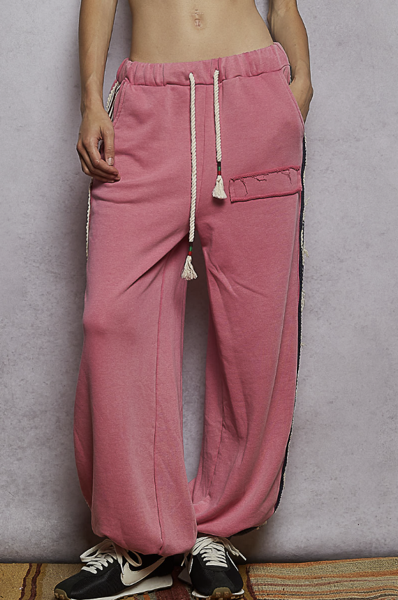 Woman wearing pink sweatpants on plain background