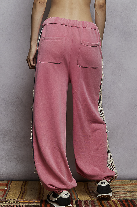 Woman wearing pink sweats on plain background