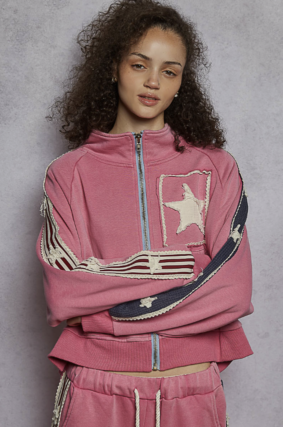 Woman wearing pink sweat suit on plain background