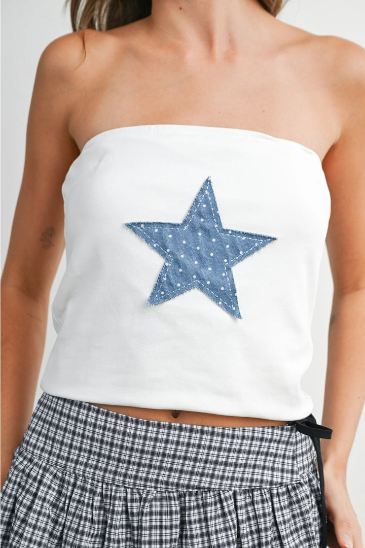Woman wearing white tube top with blue star on white background