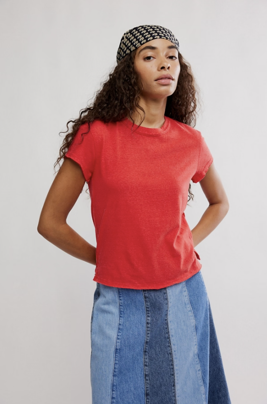 Woman wearing red tshirt and bandana with denim skirt on plain background
