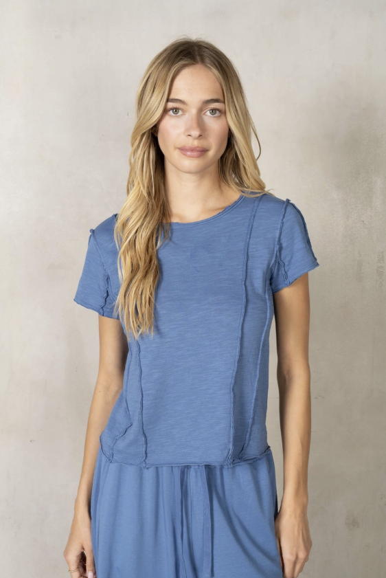 Woman wearing a blue matching set against a neutral background