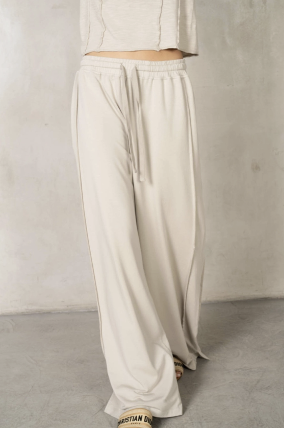 Beige wide-leg pants worn by a person on a plain background