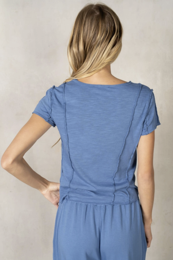 Woman wearing a blue jumpsuit against a plain background