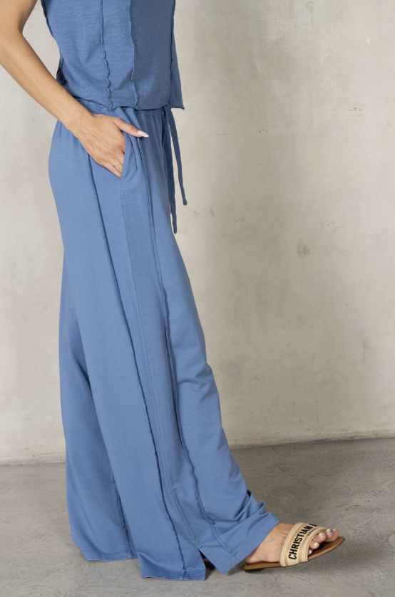 Blue outfit with wide-leg pants and a top against a neutral background