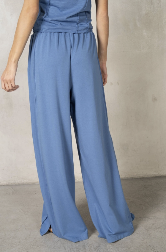 Blue jumpsuit worn by a person on a plain background